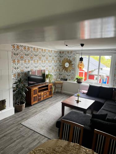a living room with a couch and a tv at Kulla Skola in Veddige