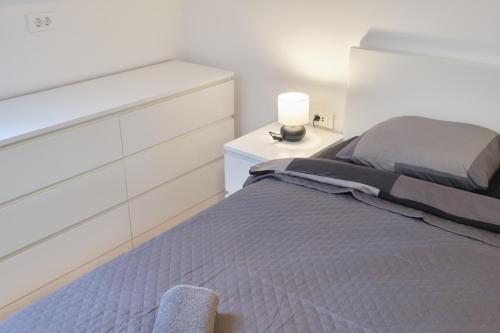 a bedroom with a bed with a dresser and a lamp at Martinović apartman in Zaprešić