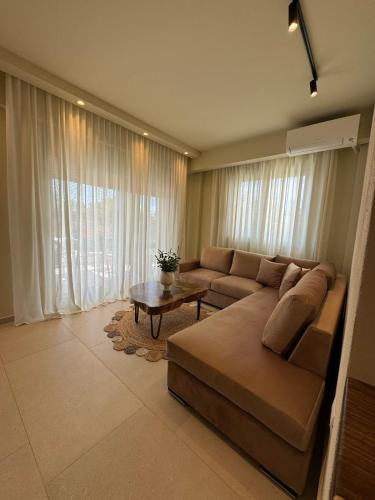 a living room with a couch and a table at Maresol in Nea Kalikratia