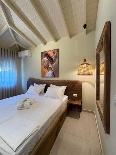 a bedroom with a bed with a painting on the wall at Maresol in Nea Kalikratia