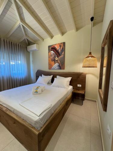 a bedroom with a bed with a painting on the wall at Maresol in Nea Kalikratia