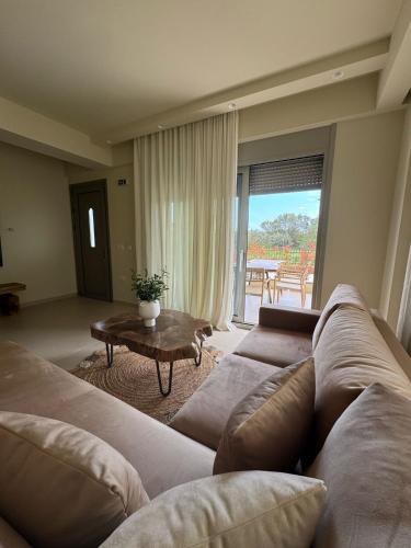 a living room with a couch and a table at Maresol in Nea Kalikratia