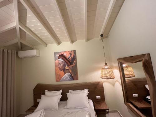 a bedroom with a bed with a painting on the wall at Maresol in Nea Kalikratia