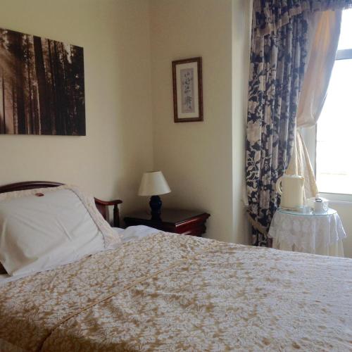 a bedroom with a bed and a window at Charnwood Guest House in Shrewsbury