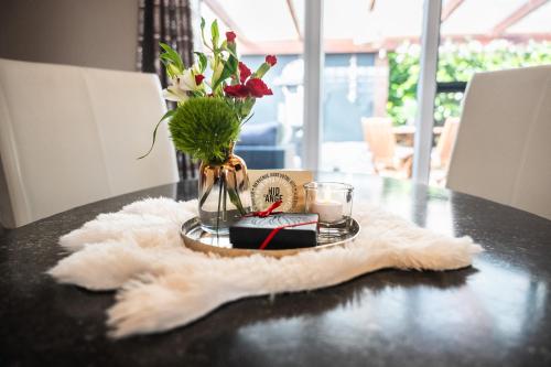 a table with a vase of flowers and a candle at Le Nid d'Ange in Ohey