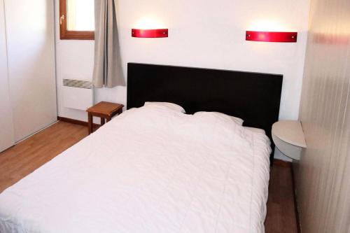 une chambre avec un lit blanc et deux lumières rouges dans l'établissement Residence La Combe D Or - Appartement en résidence de standing MAE-6344, aux Orres