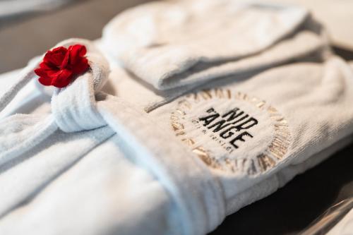 a white blanket with a red flower on it at Le Nid d'Ange in Ohey