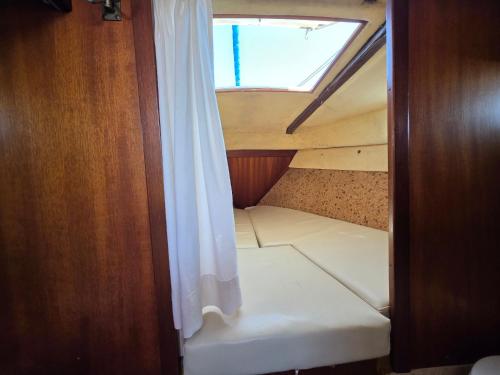 a stairway in a boat with a window at Casa barco liberdade in Faro