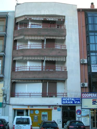 a tall building with a balcony on top of it at Hostal Gran Vía in Pinto
