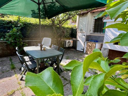 una mesa y sillas con una sombrilla en el jardín en Il noce - case vacanza-, en Sestri Levante
