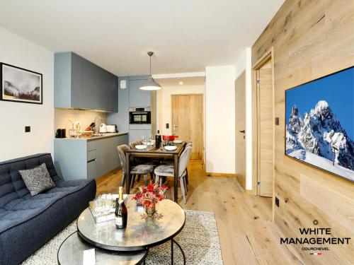 un salon avec un canapé bleu et une table dans l'établissement Résidence Ariondaz Hellebore - Beau T2 Cabine pour 5 personnes MAE-7724, à Courchevel