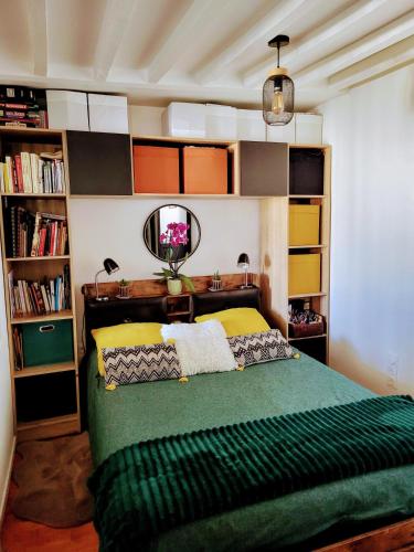 - une chambre avec un lit vert et un miroir dans l'établissement Martyrs 