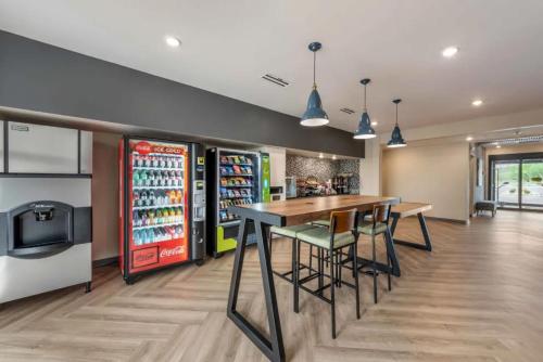 a restaurant with a table and chairs and a refrigerator at Extended Stay America Premier Suites - Colorado Springs - South in Colorado Springs