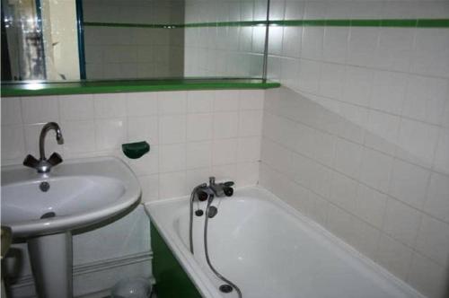 La salle de bains est pourvue d'un lavabo et d'une baignoire à côté d'un lavabo. dans l'établissement Résidence Caraibes - Appartement 2 pièces au 1er étage à LE BARCARES - CAP COUDALERE MAE-8334, au Barcarès