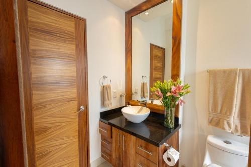 ein Badezimmer mit Waschbecken, Toilette und Spiegel in der Unterkunft Beautiful view in Gringo Gulch 202 in Puerto Vallarta