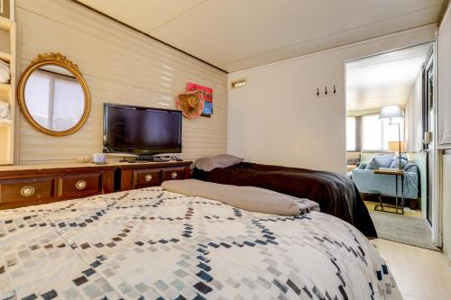 a bedroom with a bed and a flat screen tv at Pool and Hot Tub Access Home in Jensen Beach! in Jensen Beach