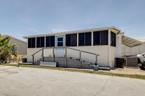 a white house with a lot of windows at Pool and Hot Tub Access Home in Jensen Beach! in Jensen Beach