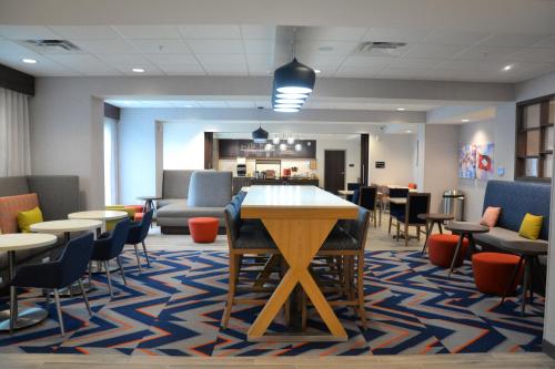 a waiting room with tables and chairs and a counter at Hampton Inn Cabot in Cabot