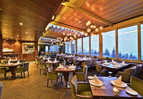 un restaurante con mesas, sillas y ventanas en Marigold Thermal & Spa Hotel Bursa, en Bursa
