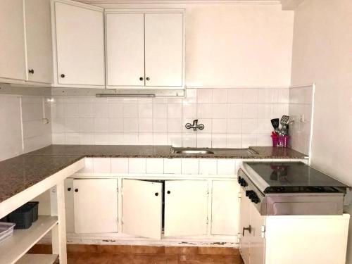 une cuisine avec des armoires blanches et un évier dans l'établissement Charming house in Imi Ouddar, à Agadir nʼ Aït Sa