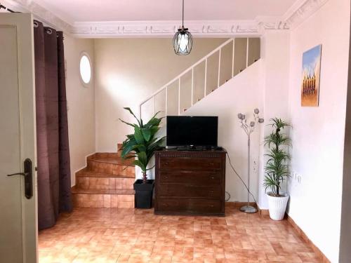 d'un salon avec une télévision sur une commode et des escaliers. dans l'établissement Charming house in Imi Ouddar, à Agadir nʼ Aït Sa