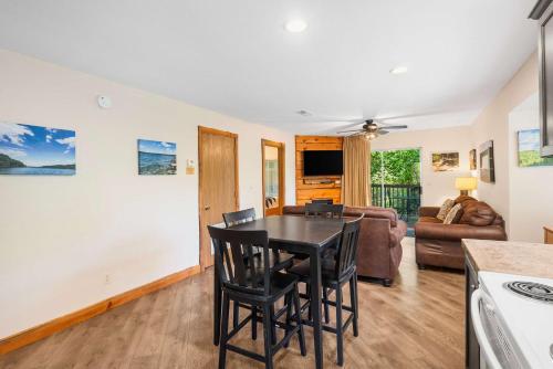 a kitchen and living room with a table and chairs at Cozy Timbers - Charming Condo for 6 with Resort-style Amenities in Branson