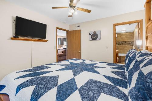 a bedroom with a bed and a flat screen tv at Cozy Timbers - Charming Condo for 6 with Resort-style Amenities in Branson