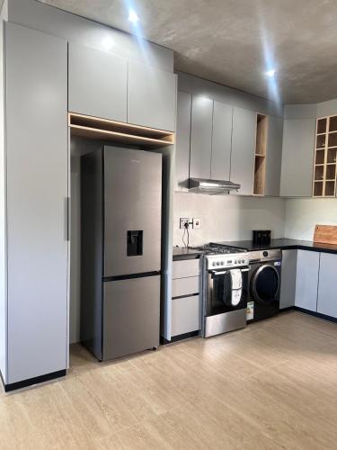 a kitchen with a refrigerator and a washer and sink at Coastal bliss at YnS apartment! in La Mercy