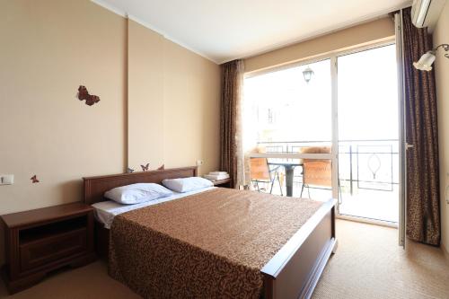 een hotelkamer met een bed en een balkon bij Първа линия Апартаменти in Pomorie