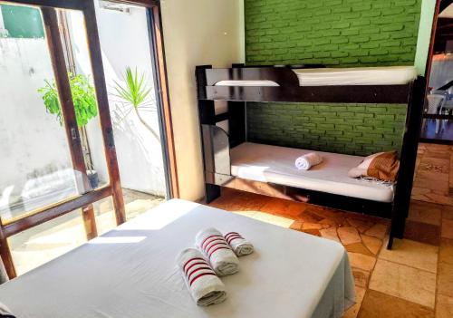 a room with two bunk beds and a table with slippers at Pipa Universo in Pipa