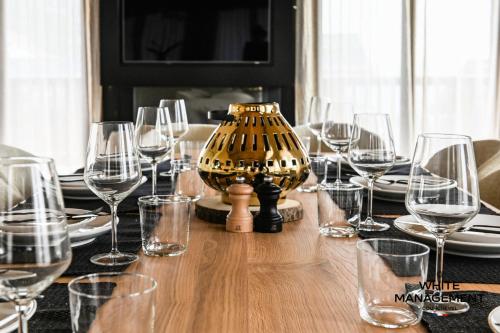 - une table avec des verres à vin et un vase dans l'établissement Résidence Les Glaciers - Chaleureux chalet contemporain à Courchevel 1650 MAE-4431, à Courchevel