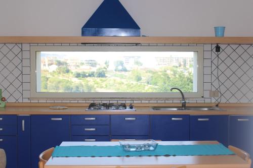 a kitchen with a large window above a sink at Cuore Di Palme in Floridia