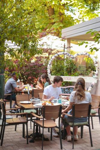 a group of people sitting at tables in a restaurant at Boutique Hotel Asteria in Ljubljana