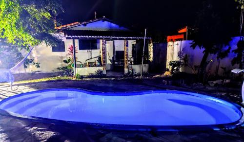 a swimming pool in front of a house at night at Pipa Universo in Pipa