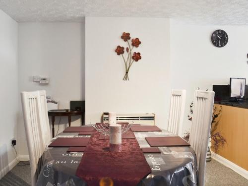 a dining room with a table and a vase of flowers on the wall at Banovallum Cottage in Horncastle