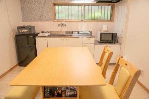 a kitchen with a wooden table with chairs and a sink at Komorebi no Yado - Vacation STAY 19011v in Goto
