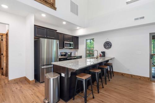 a kitchen with a large island with bar stools at Peaceful Timbers Getaway in Hollister