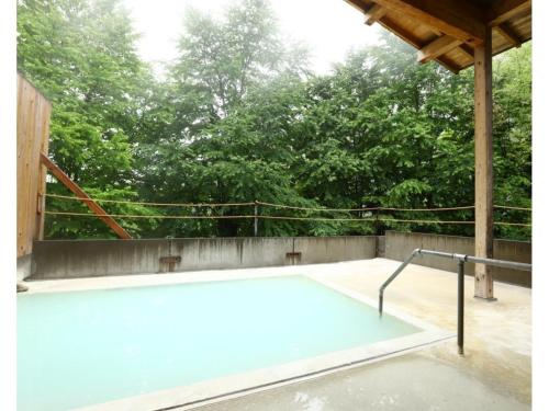 a swimming pool on a patio with trees in the background at Ebisuya - Vacation STAY 31583v in Hirayu