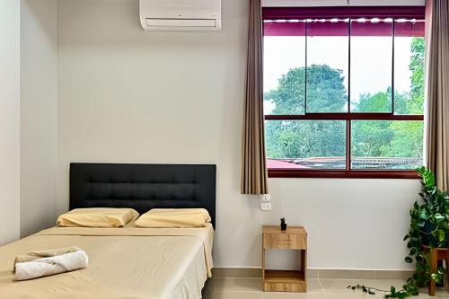 Un dormitorio con dos camas y una ventana. en Depa a 5min centro 2HAB con A/C Terraza y Parrilla, en Tarapoto