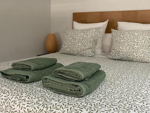 - un lit avec des draps et des oreillers verts dans l'établissement Apartamento La Machacona TENERIAS, à Cáceres