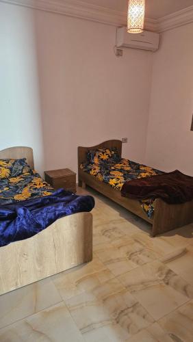 a room with two beds in a room with a floor at Private Family Villa with Pool Garden and Parking spot 3BR 2BA in Al Maqārisah
