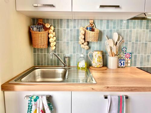 un comptoir de cuisine avec un évier et des paniers au mur dans l'établissement Le Petit Nice, à Nice