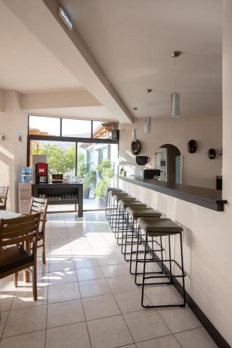 a row of stools in a kitchen with a bar at Seaside apartments in Alikí