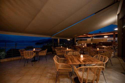 a restaurant with tables and chairs on a patio at Seaside apartments in Alikí