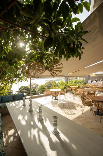 a patio with tables and chairs and a table with a chessboard at Seaside apartments in Alikí