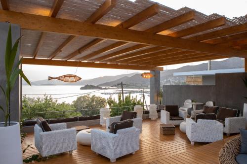 a patio with white chairs and a view of the ocean at Seaside apartments in Alikí