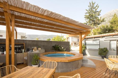 a patio with a hot tub and a wooden deck at Seaside apartments in Alikí