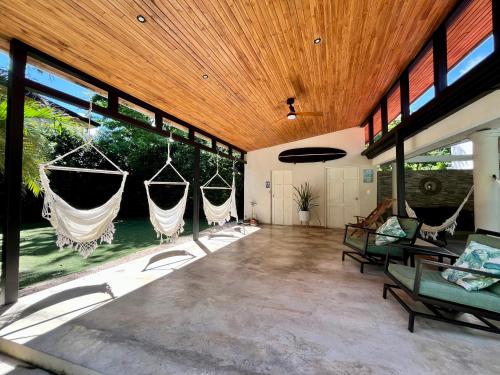 a large room with hammocks in it with windows at Hotel El Manglar in Playa Grande