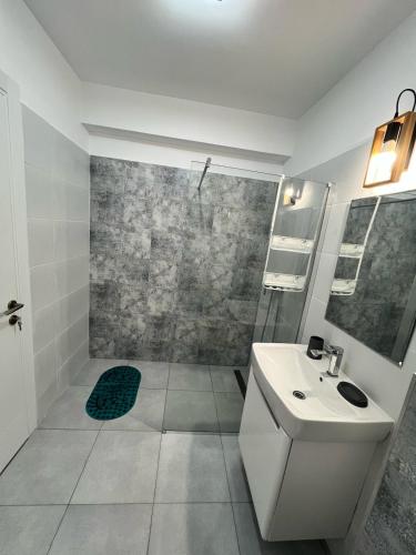 a white bathroom with a shower and a sink at SeaTok & Stay in Costinesti