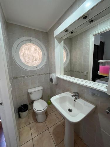 a bathroom with a sink and a toilet and a mirror at BbCasita Blue in Santiago